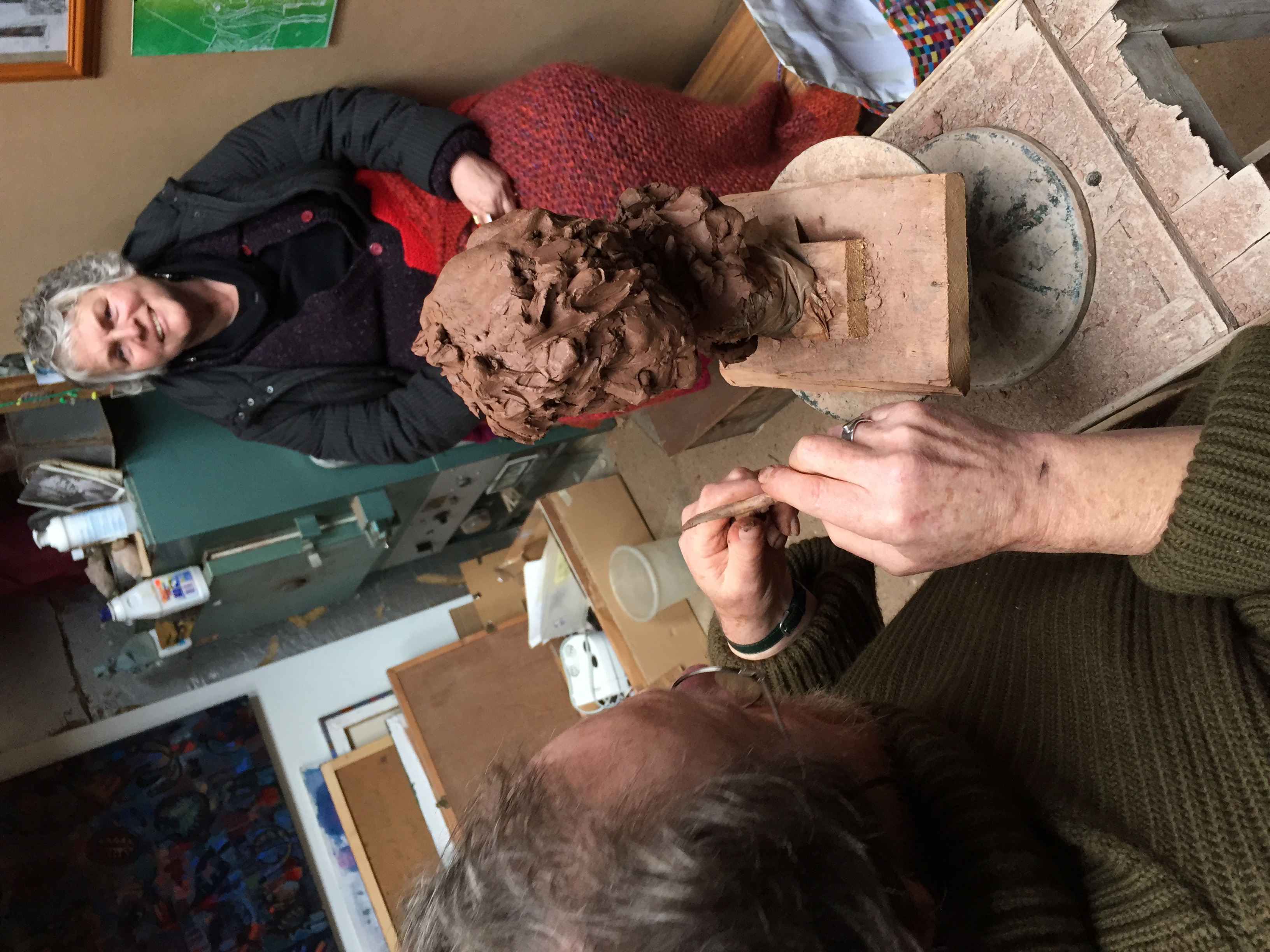 Simon Britton modelling a clay portrait head from life in his studio